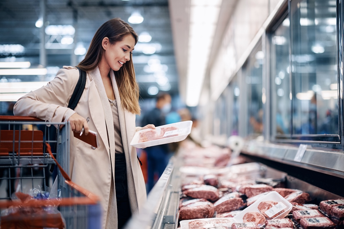 Consumer selecting meat products at a supermarket